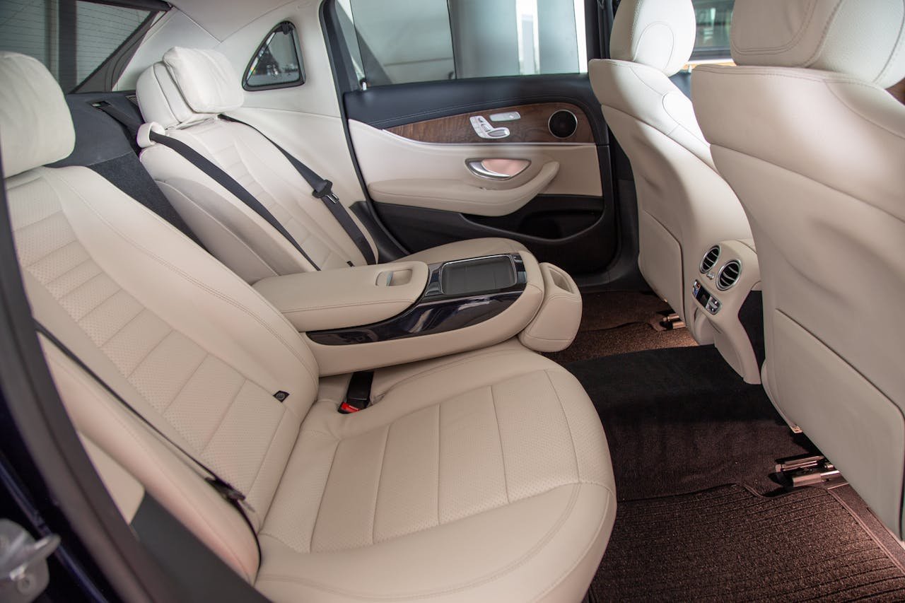 Spacious luxury car interior featuring elegant white leather seats and premium design elements.